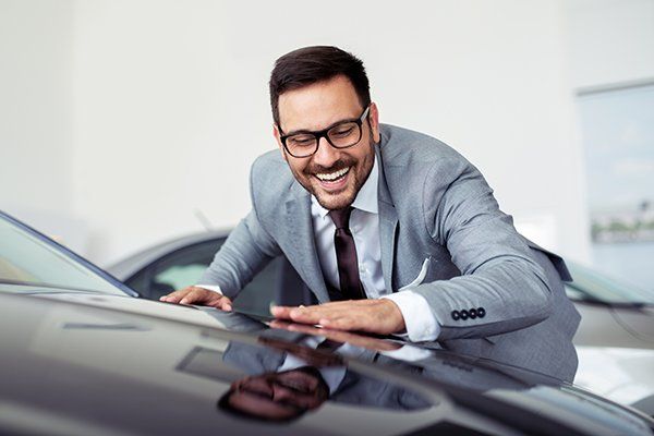 Man Smiling and Embracing a New Car — Chicago, IL — Illinois Insurance Center Inc