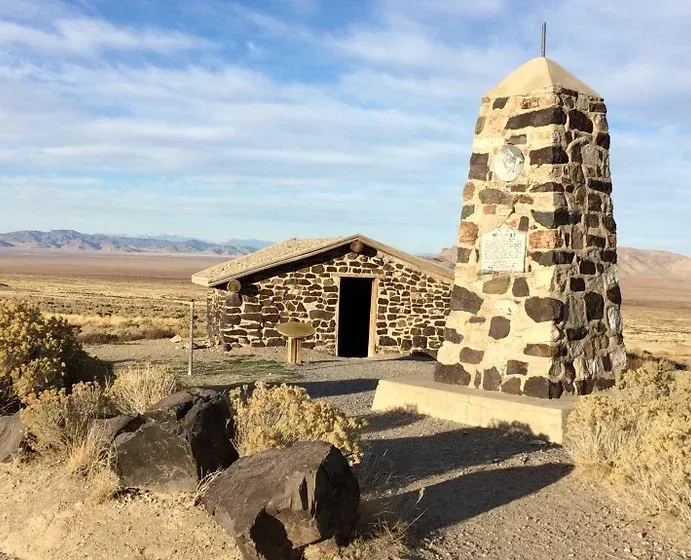 A small stone building in the middle of a desert