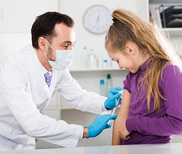 Male Doctor Injecting Little Patient — Benton County Health Department — Warsaw, MO