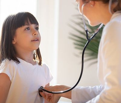 Pediatrician with Stethoscope Listening to the Heart of a Child — Benton County Health Department — Warsaw, MO