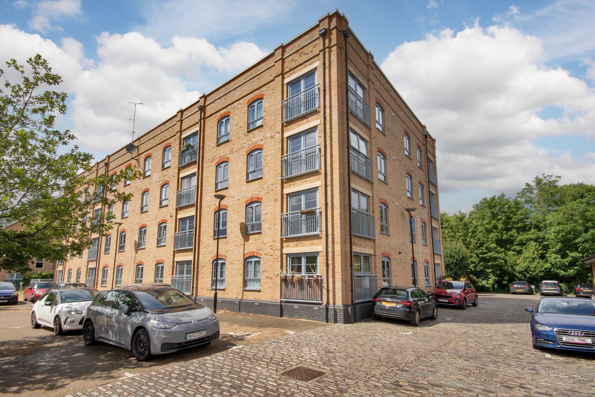 A large brick building with cars parked in front of it.