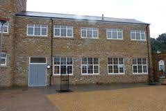 A large brick building with a lot of windows and a blue door.