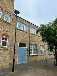 A brick building with a blue door and a street light in front of it.