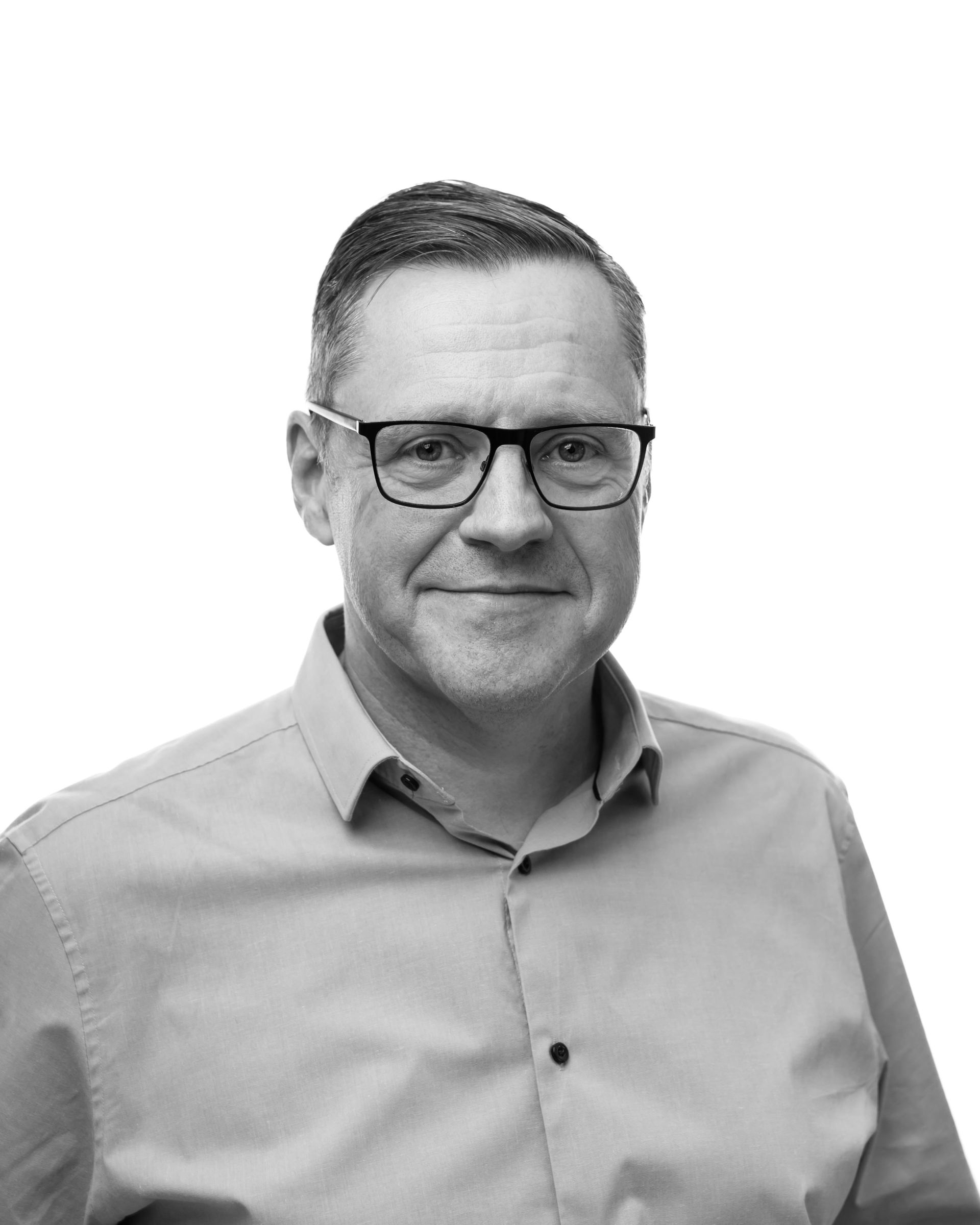 A black and white photo of a man wearing glasses and a shirt.