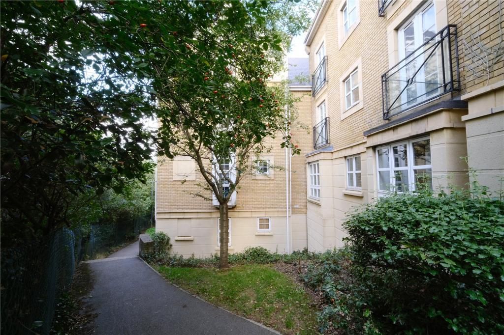 A path leading to a building with a tree in front of it.