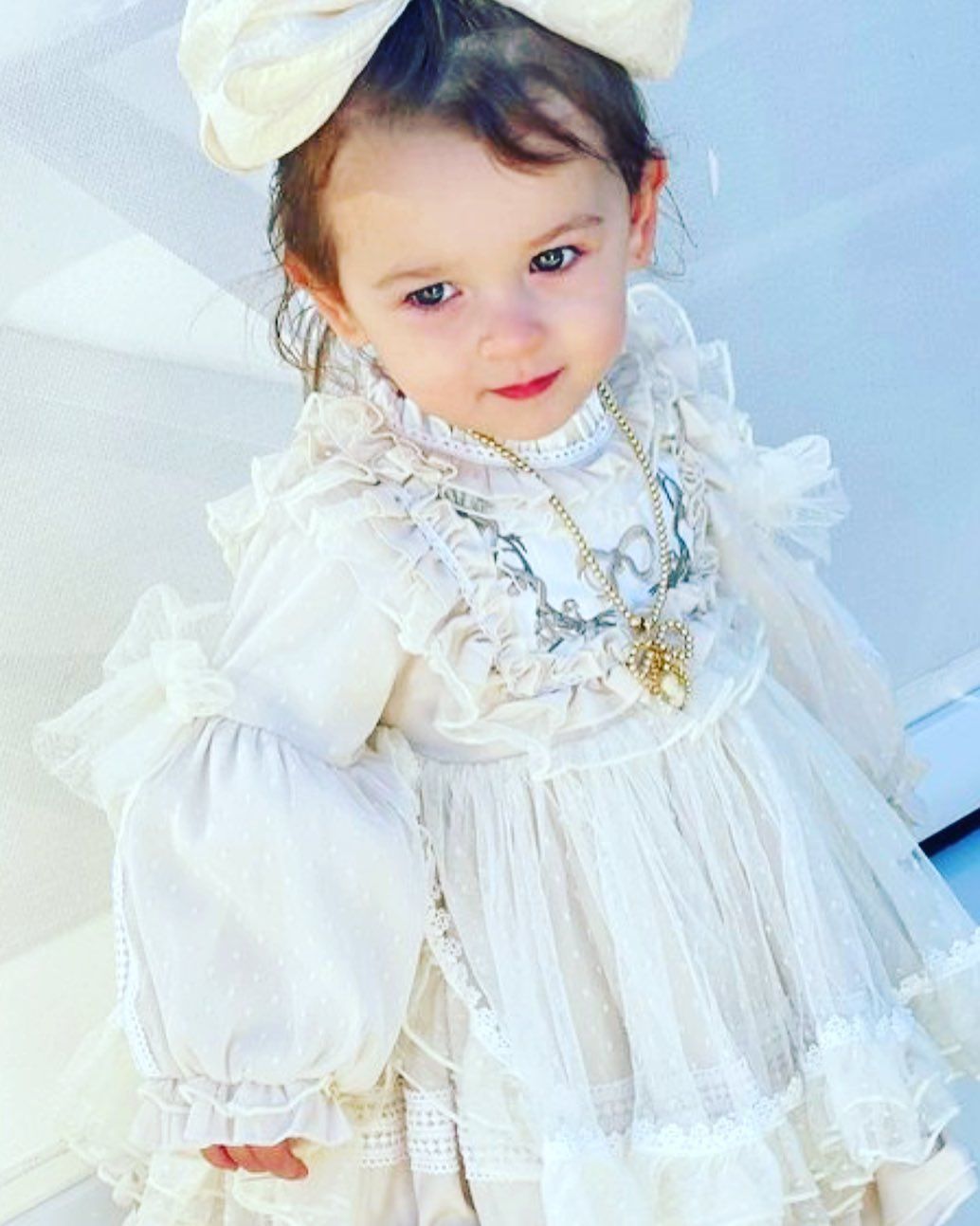 A Little Girl Is Wearing a White Dress and A White Bow - Saint Georges, DE - Chavies Boutique
