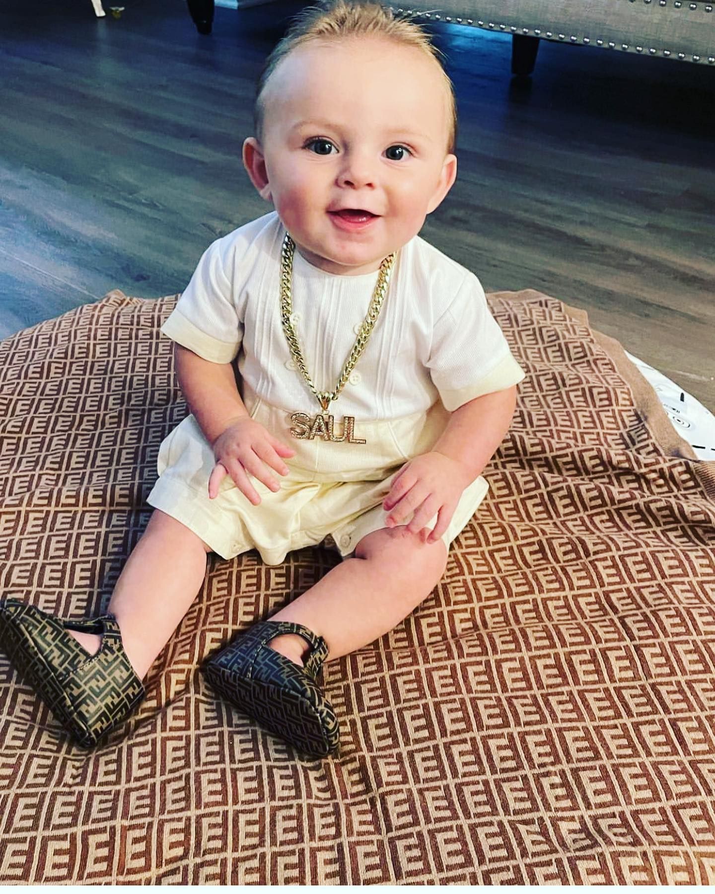 A Baby Wearing a Fendi Outfit Is Sitting on A Blanket - Saint Georges, DE - Chavies Boutique