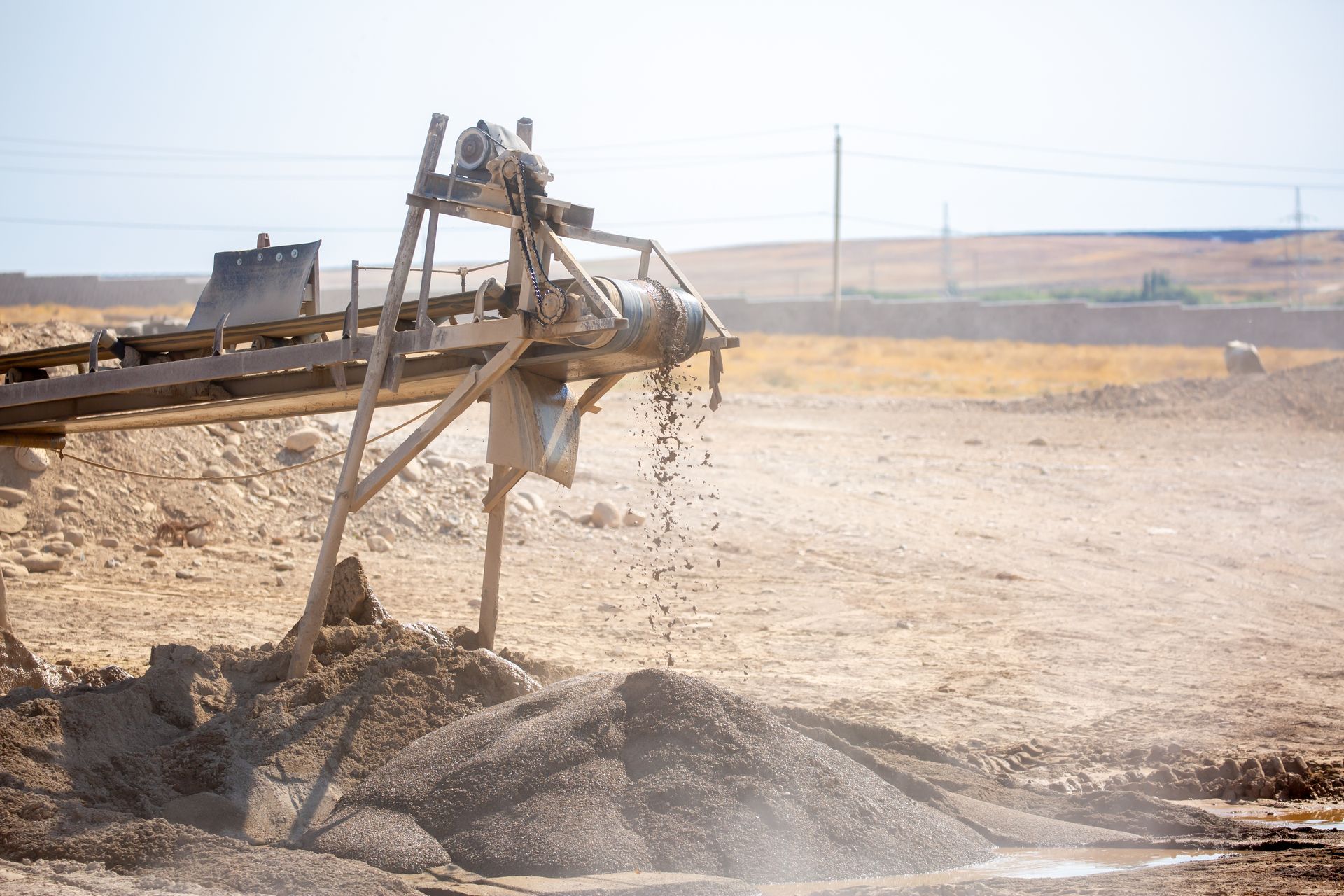 Vibrating screen crusher separating crushed stone material during on-site processing. Vibrating screen crusher separating crushed stone material during on-site processing.