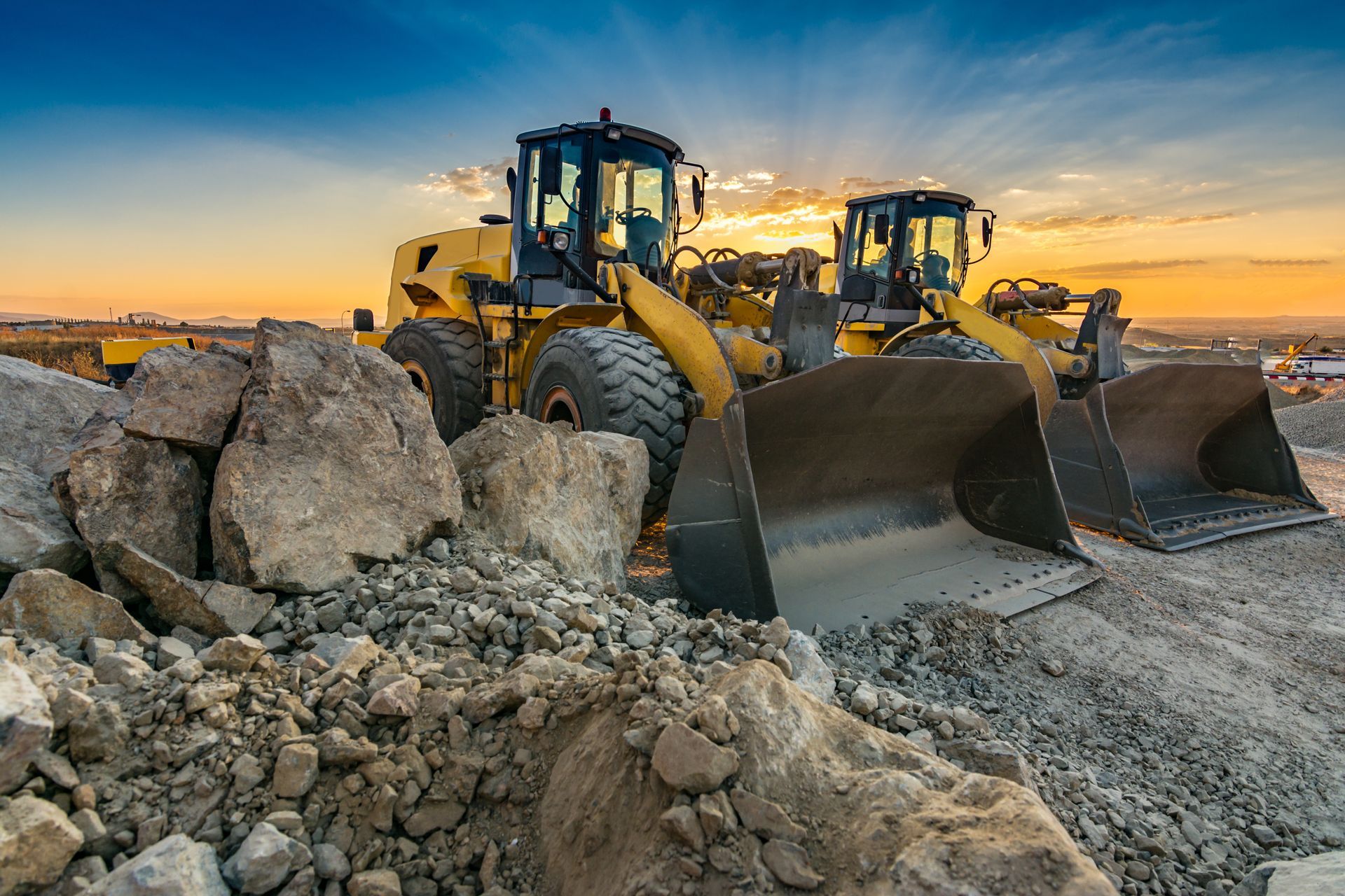 Two excavators are removing stones in the construction works of a road.