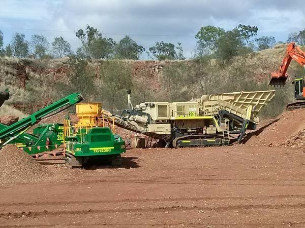 beige crusher by green tractor
