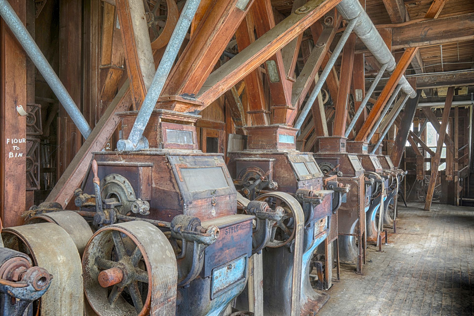 Row of antique pugmills for sale inside old processing facility with wooden beams. Row of antique pugmills for sale inside old processing facility with wooden beams.