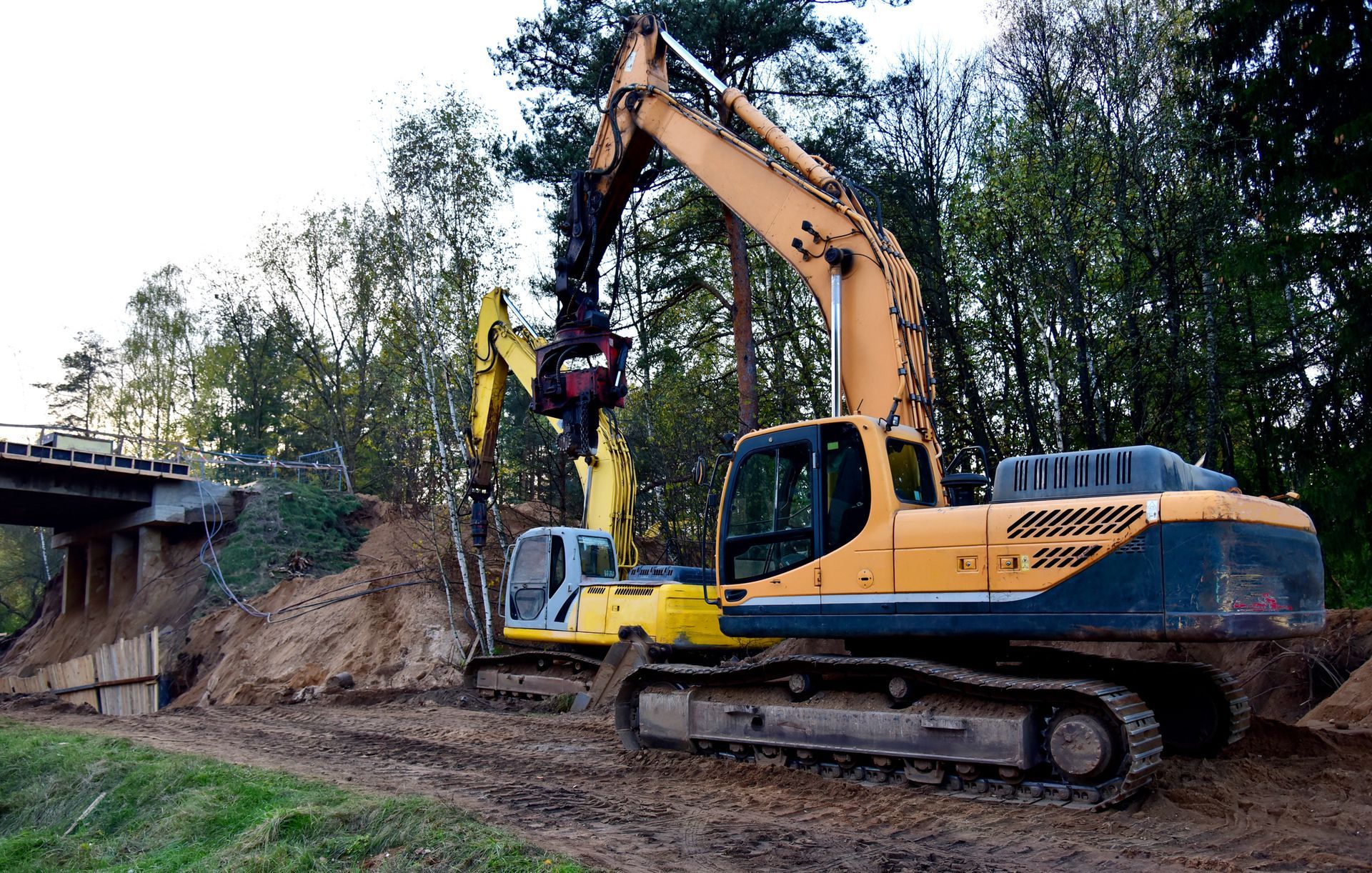 Yellow excavator with a crane.