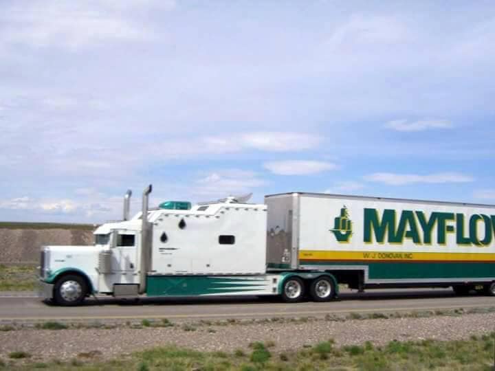 White Mayflower moving truck on a road under a cloudy sky