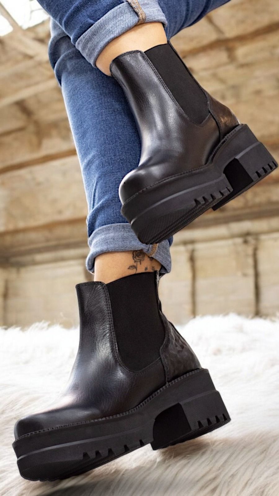Primer plano de una persona que lleva botas de plataforma estilo Chelsea de cuero negro