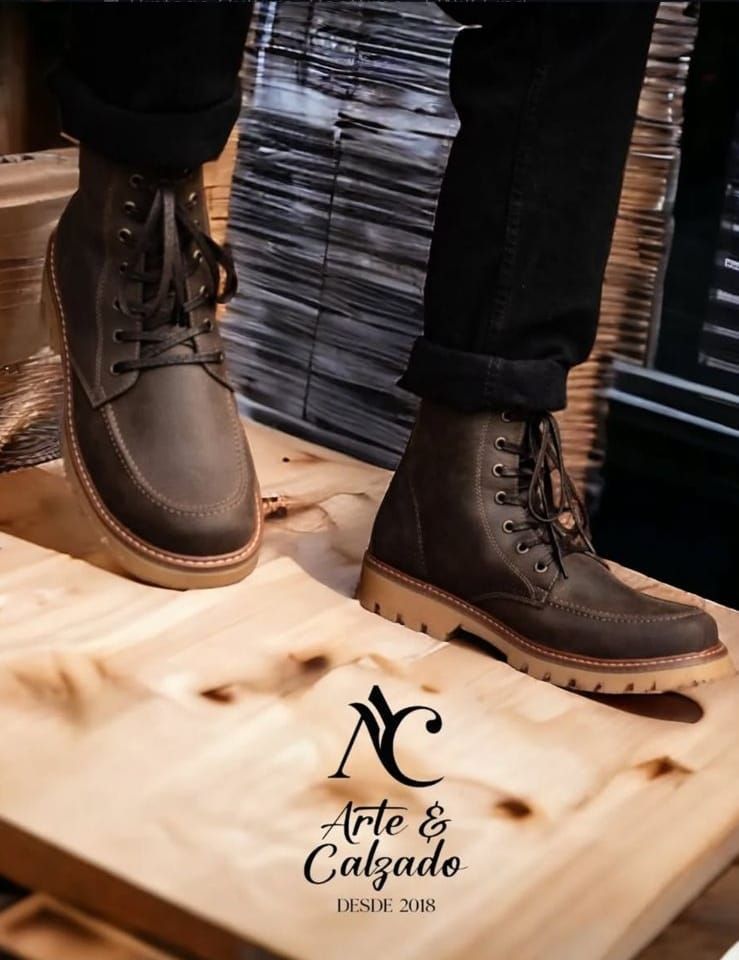 Un par de botas marrones de cuero con cordones, combinadas con vaqueros