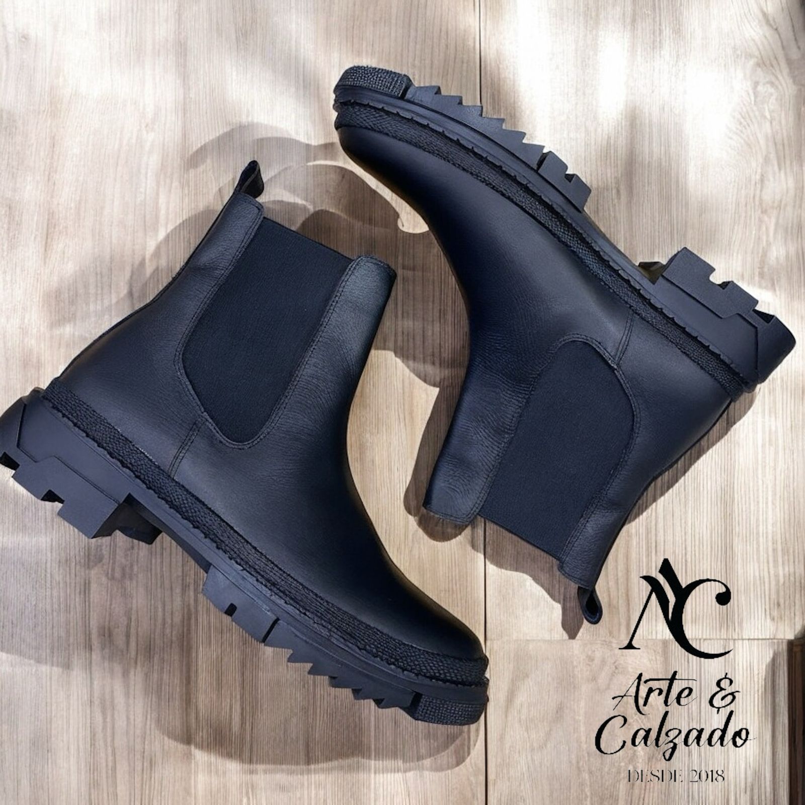 Un par de botines Chelsea de cuero marrón con paneles laterales elásticos negros y suelas gruesas con relieve