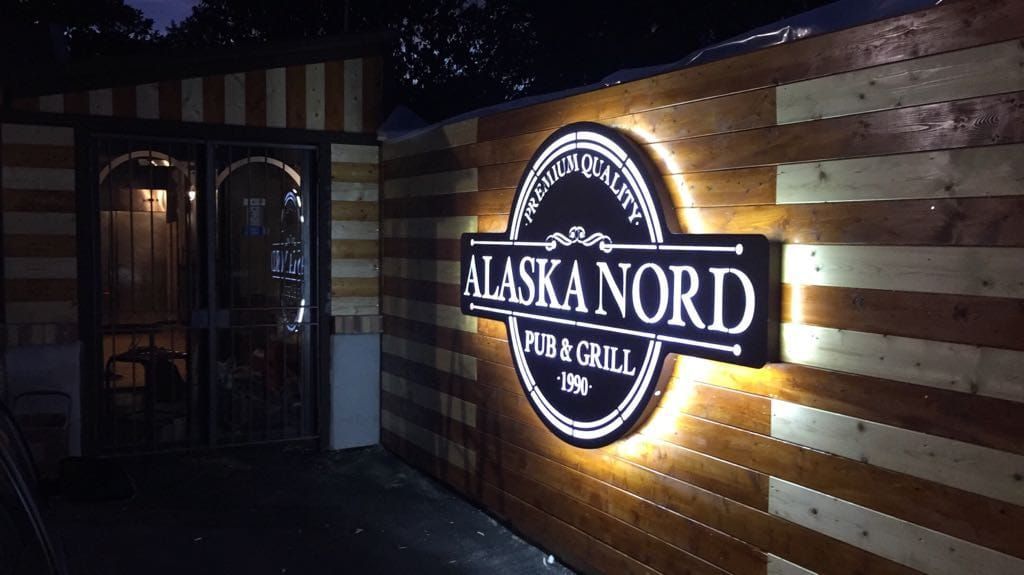 Di notte, un'insegna circolare illuminata con la scritta