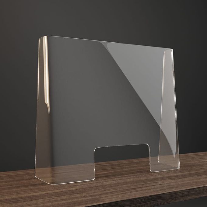 Barriera protettiva trasparente in acrilico con apertura passante, posizionata su una superficie di legno scuro su sfondo grigio.