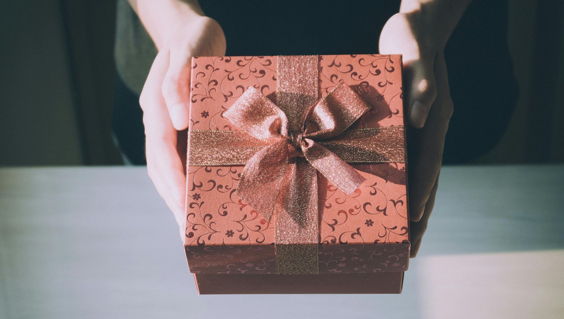 A pink gift box wrapped with a ribbon