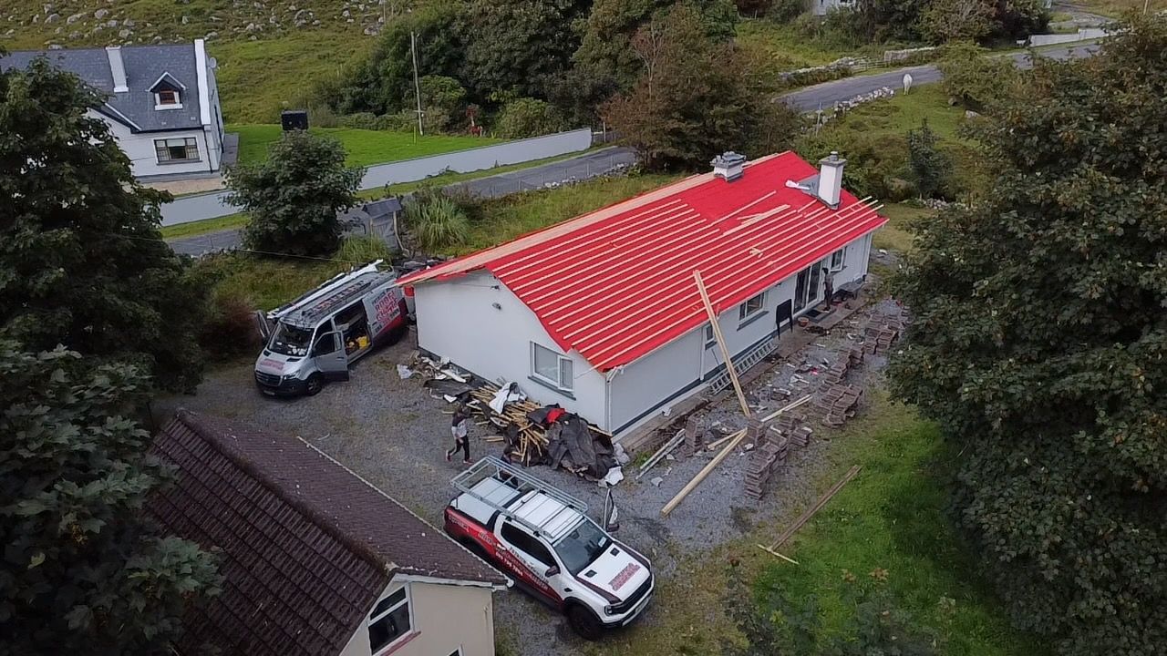 A van is parked in front of a house with solar panels on the roof.