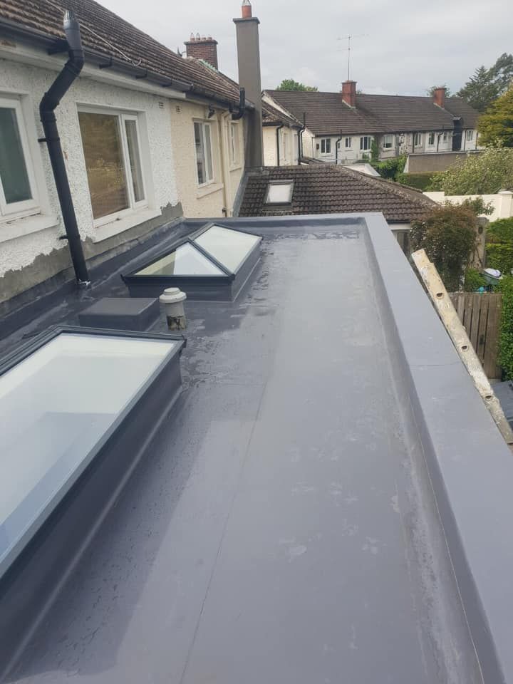 The roof of a house with a skylight on it.