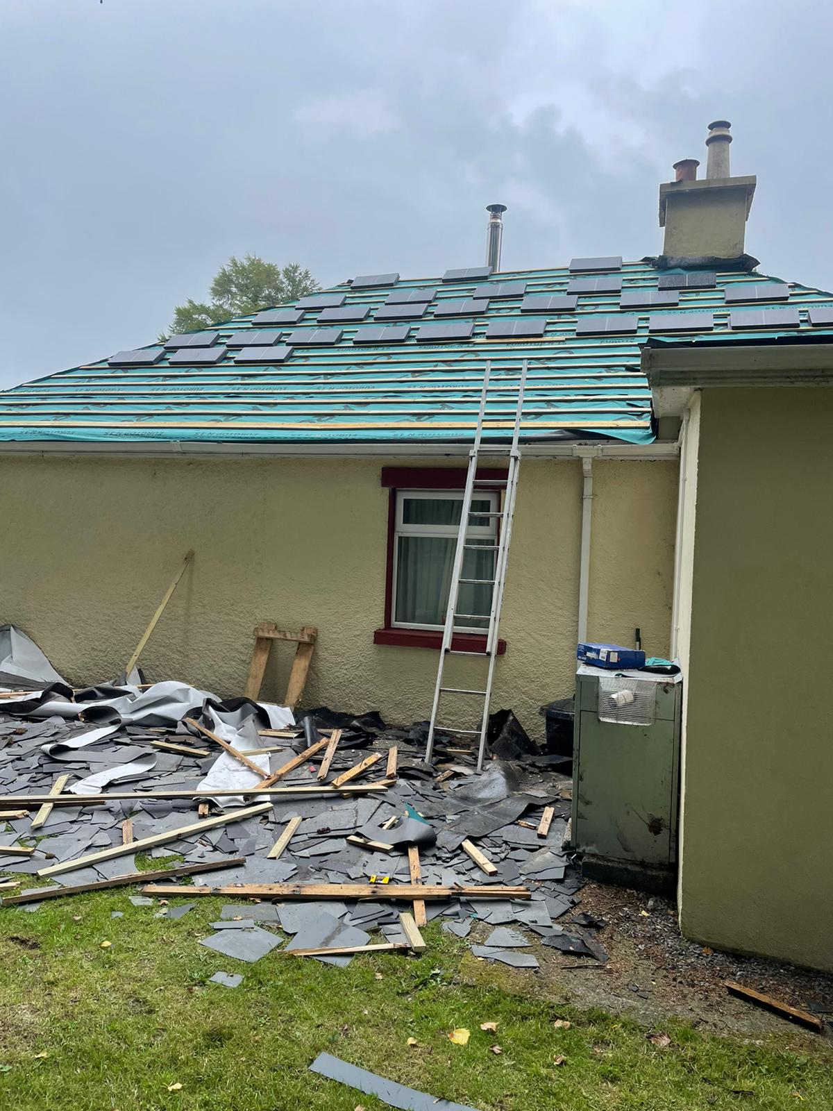 A house with a ladder on the side of it is being remodeled.