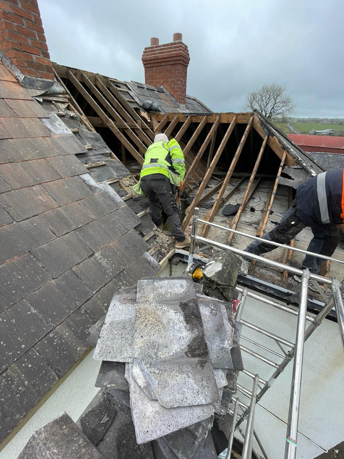 Two men are working on the roof of a building.