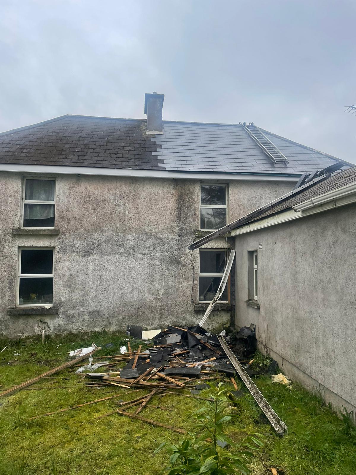A house with a roof that has been damaged by a storm.