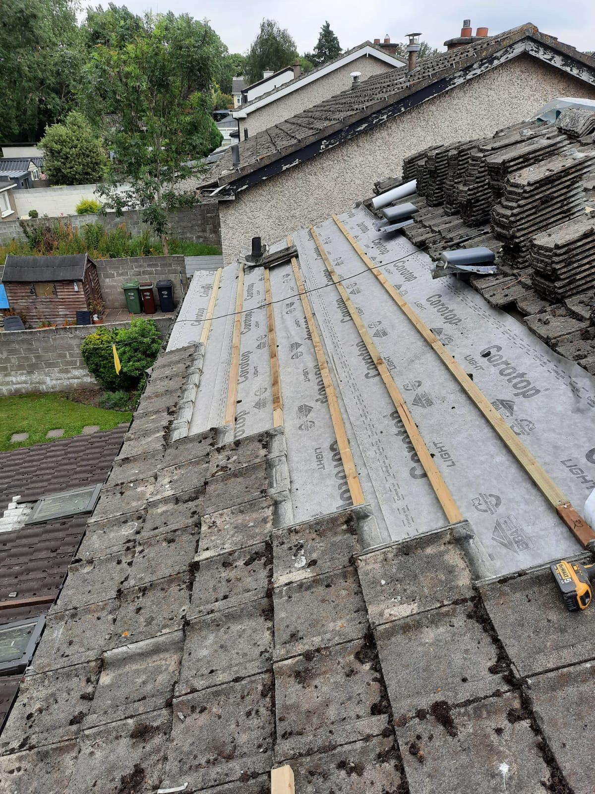 A roof with a lot of tiles on it is being repaired.