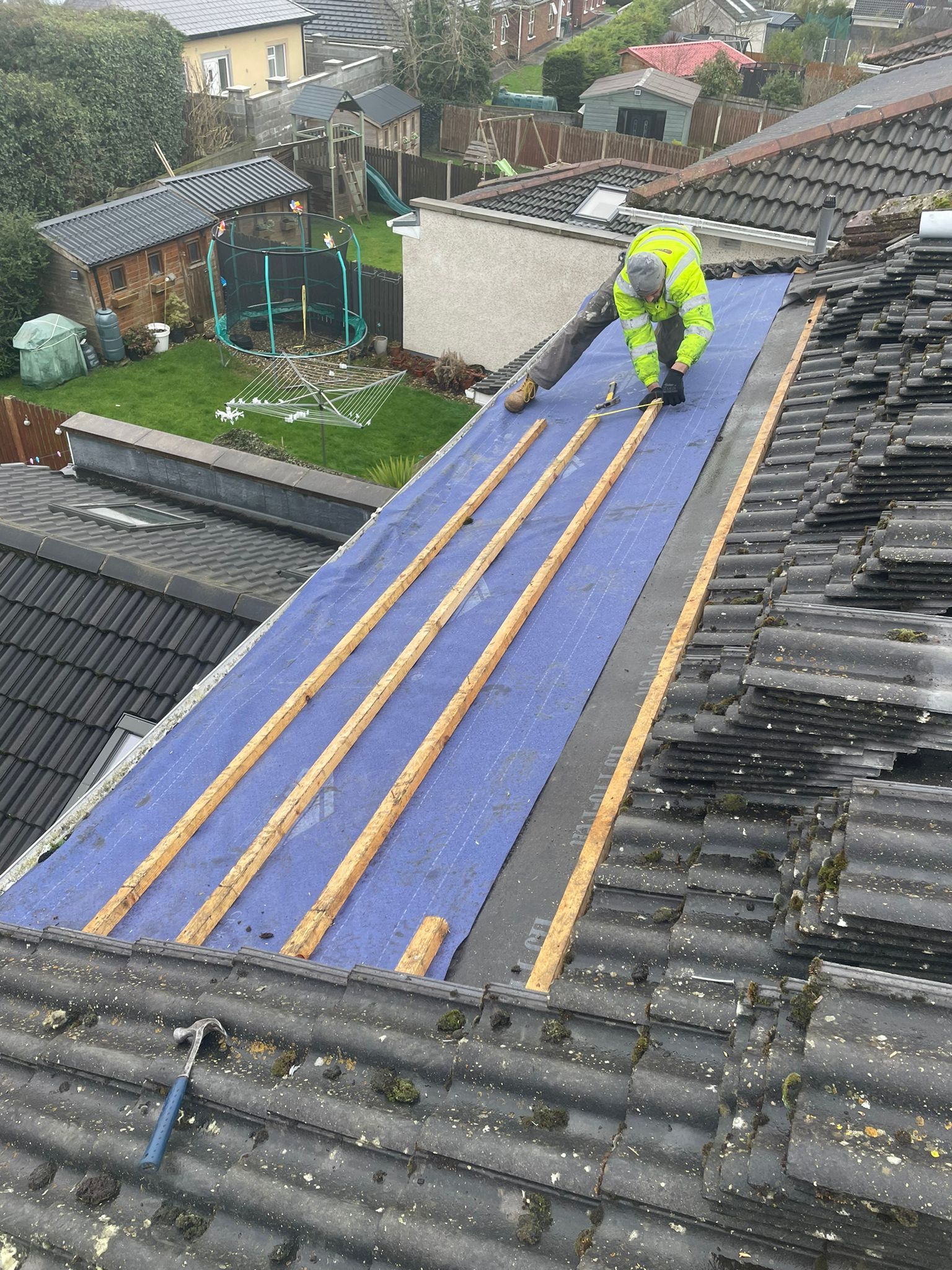 A man is working on the roof of a house.