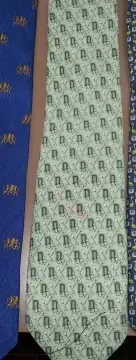 Five men's neckties with various patterns and colors—light grey, blue, pale green, and dark navy—laid side-by-side.