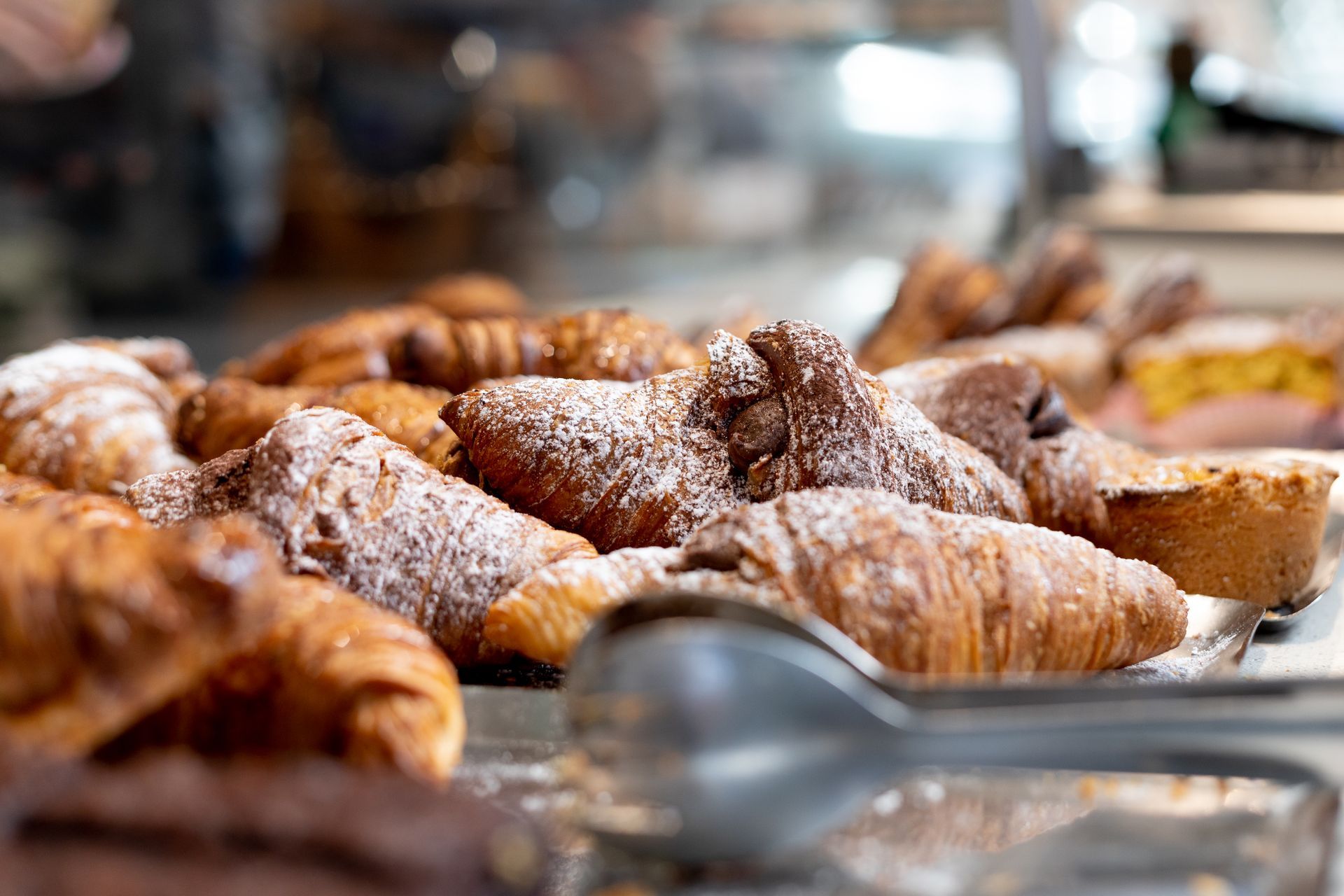Cornetti spolverati di zucchero a velo esposti in una panetteria.