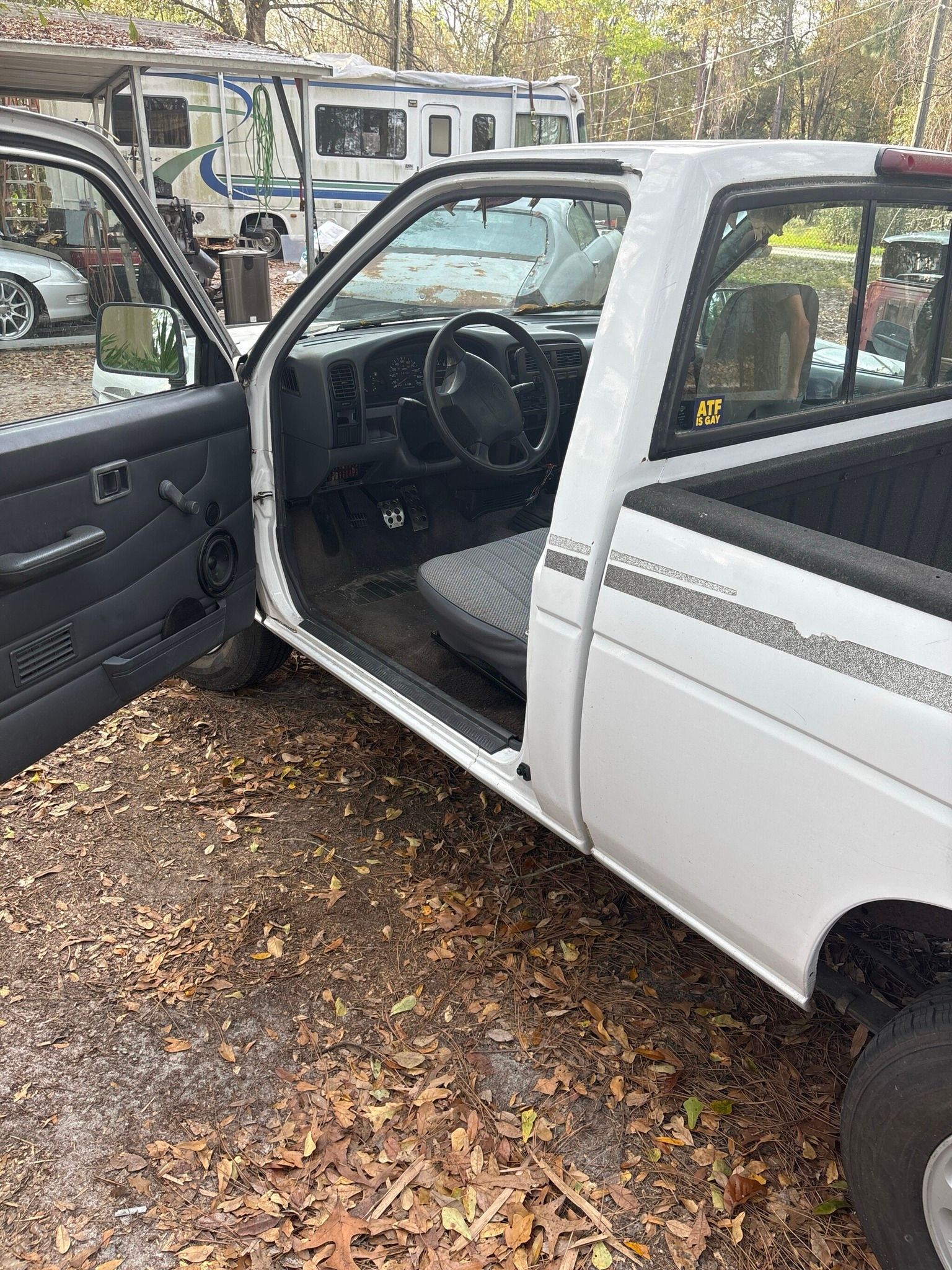 A white truck is parked in a parking lot with its doors open.