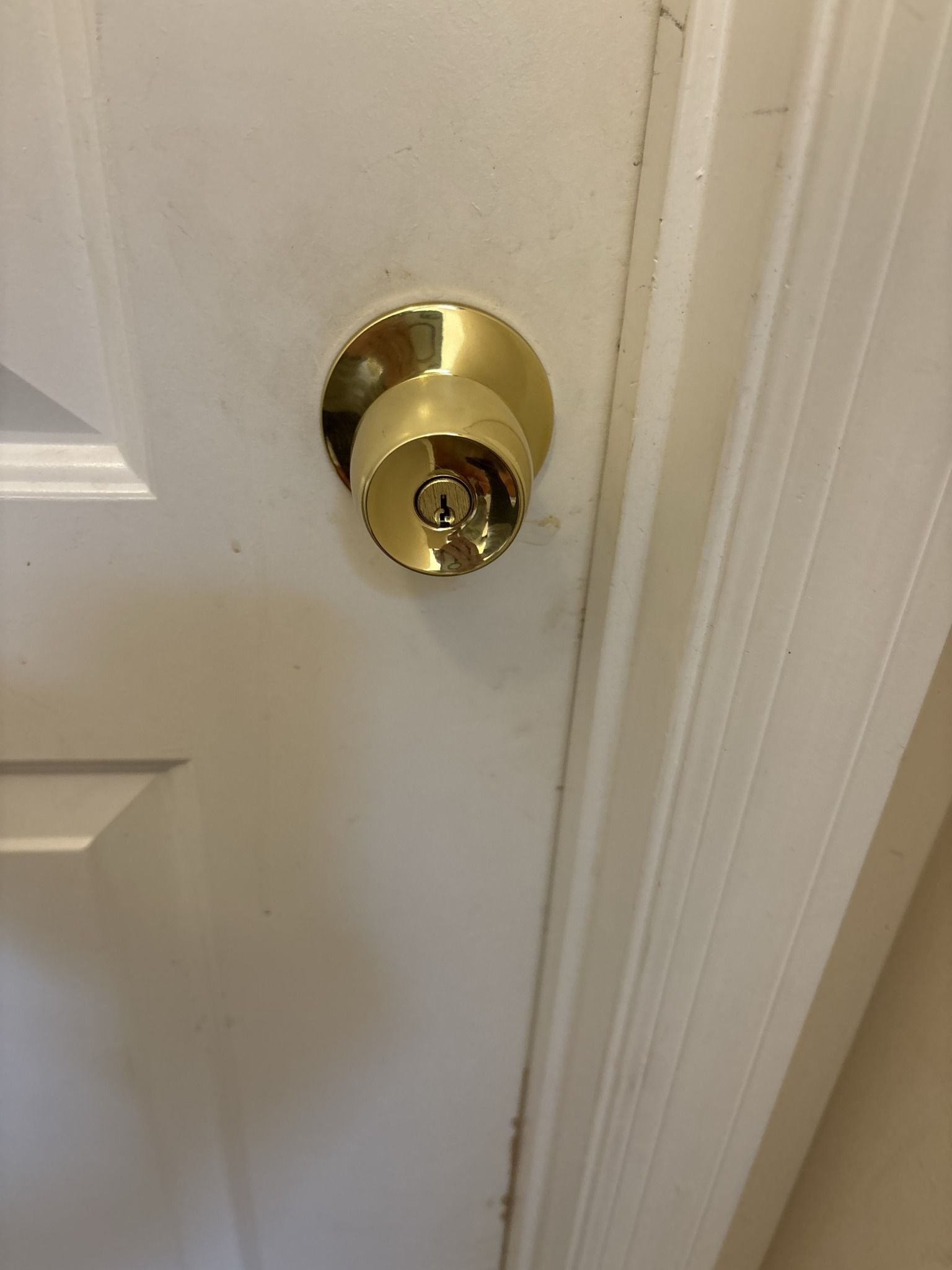 A close up of a door knob on a white door.