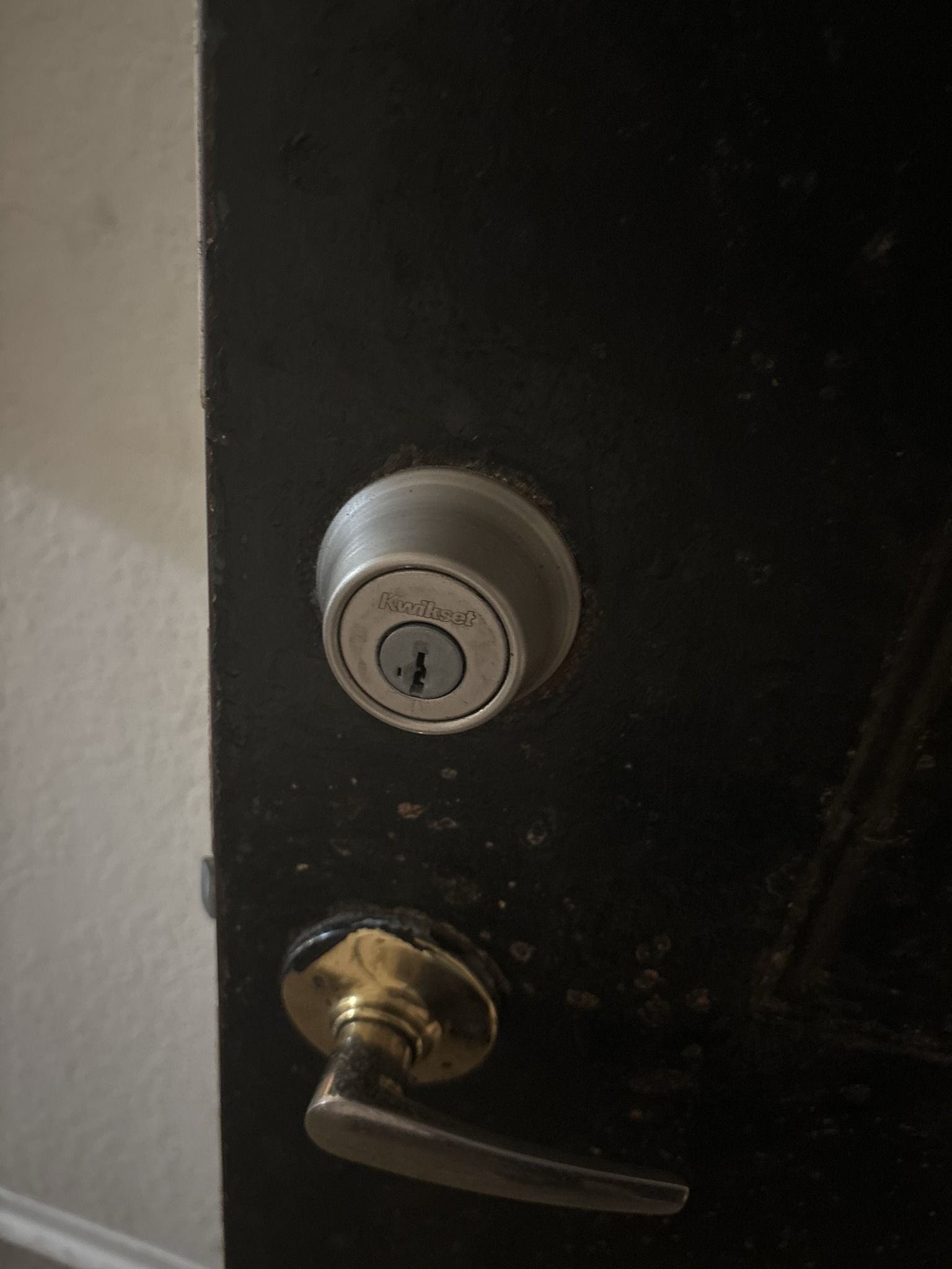 A close up of a door lock on a black door.