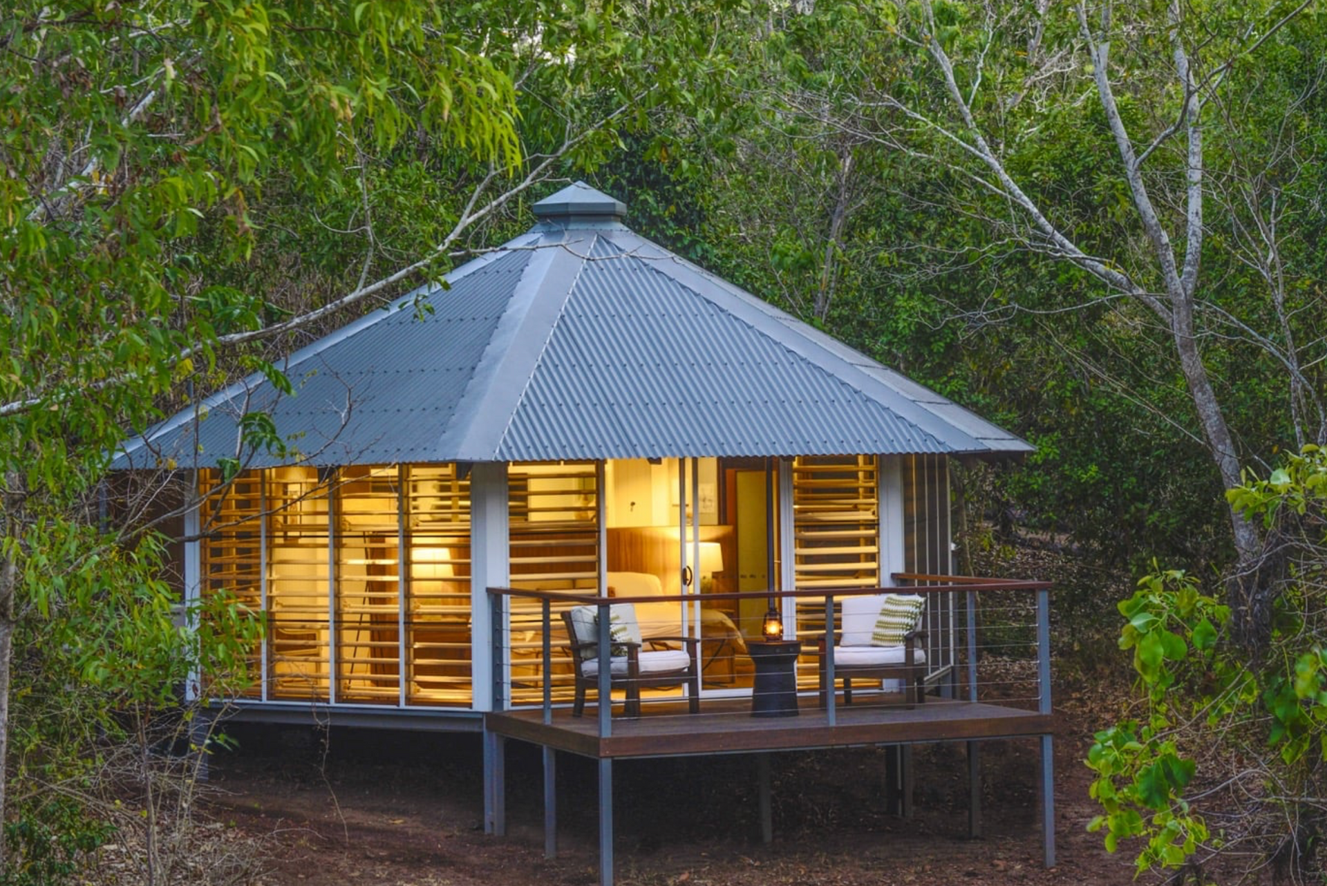 Cabin With Wooden Shutters and a Corrugated Metal Roof, Nestled in Lush Greenery — Northco Constructions In Muirhead, NT