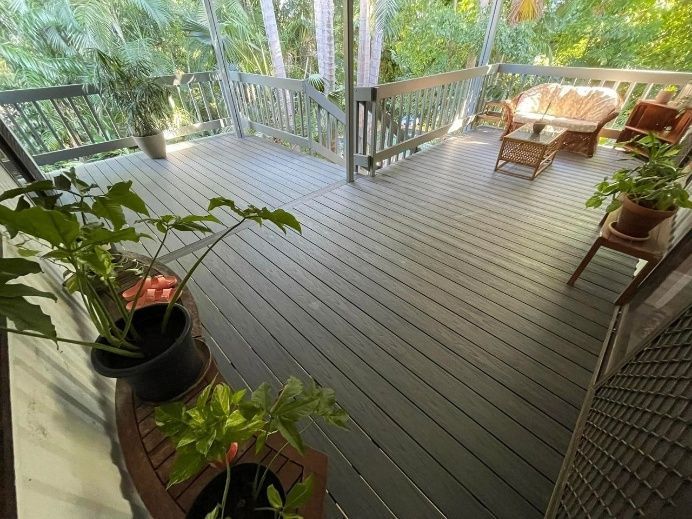 A Wooden Deck With Gray Planks, Furnished With Wicker Chairs — Northco Constructions In Muirhead, NT