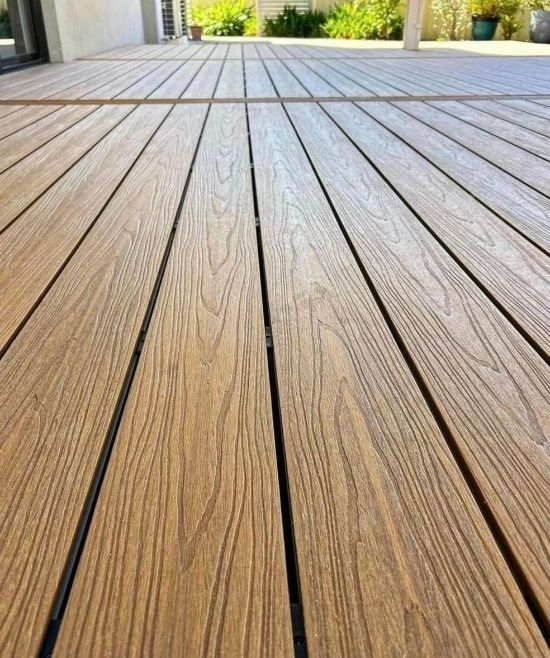 Close-up View of a Wooden Deck With Brown Planks and Thin Black Gaps — Northco Constructions In Muirhead, NT