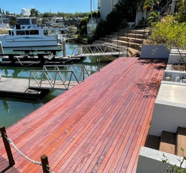 Wooden Dock Extending Over Water, Leading to a Boat and Stairs — Northco Constructions In Muirhead, NT