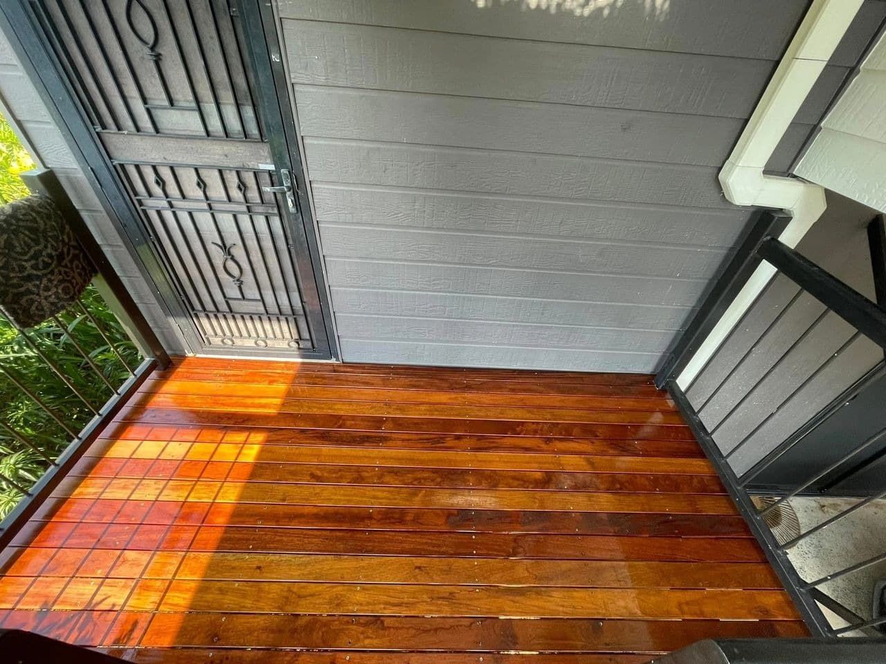 Wooden Deck With a Dark Brown Finish, Beneath a Gray Roof and Gate — Northco Constructions In Nightcliff, NT