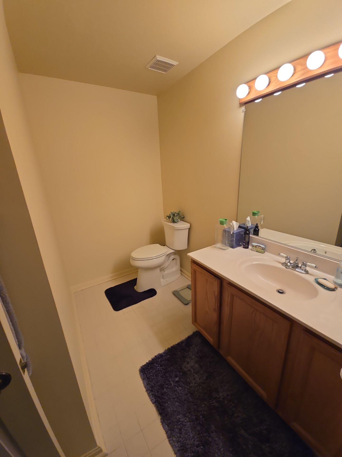 A bathroom with a toilet , sink , and mirror.