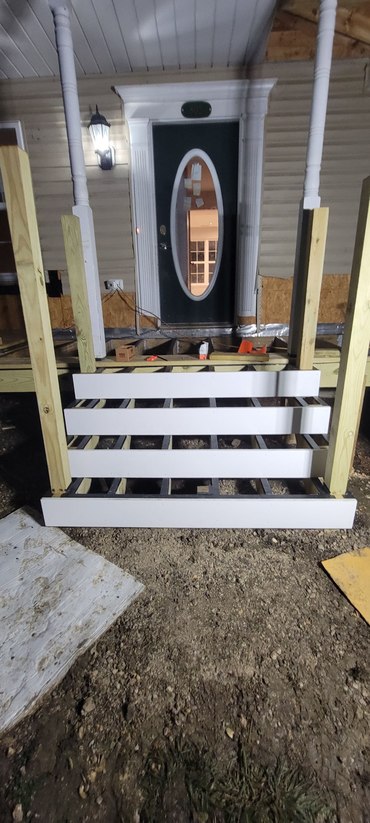 A wooden porch is being built in front of a house.