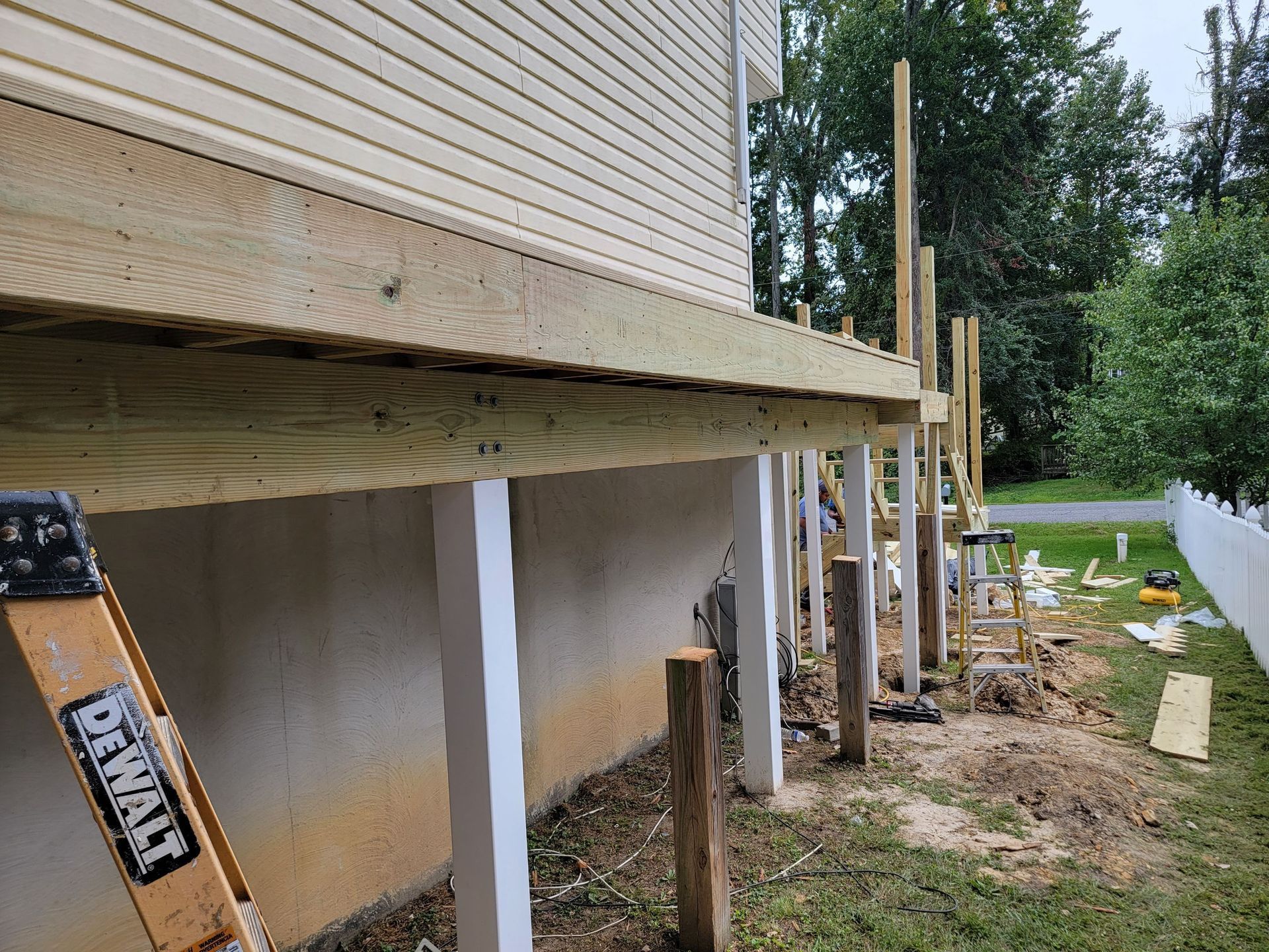 A wooden deck is being built on the foundation of a house.