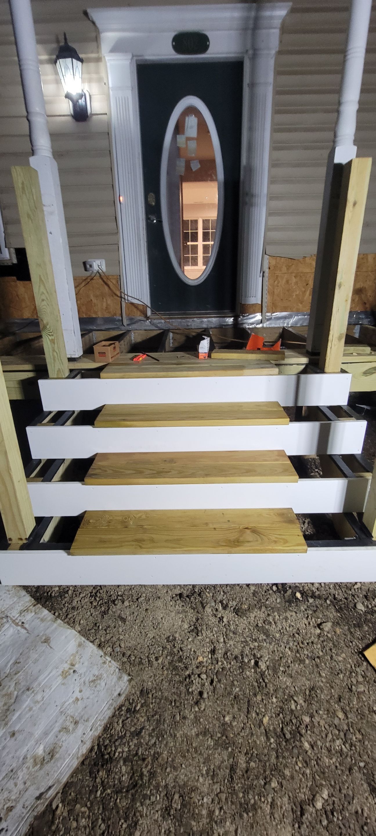 A wooden porch is being built in front of a house.