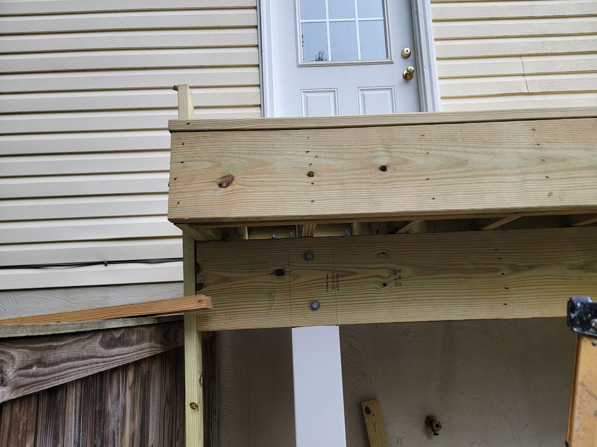 A wooden deck is being built on the side of a house
