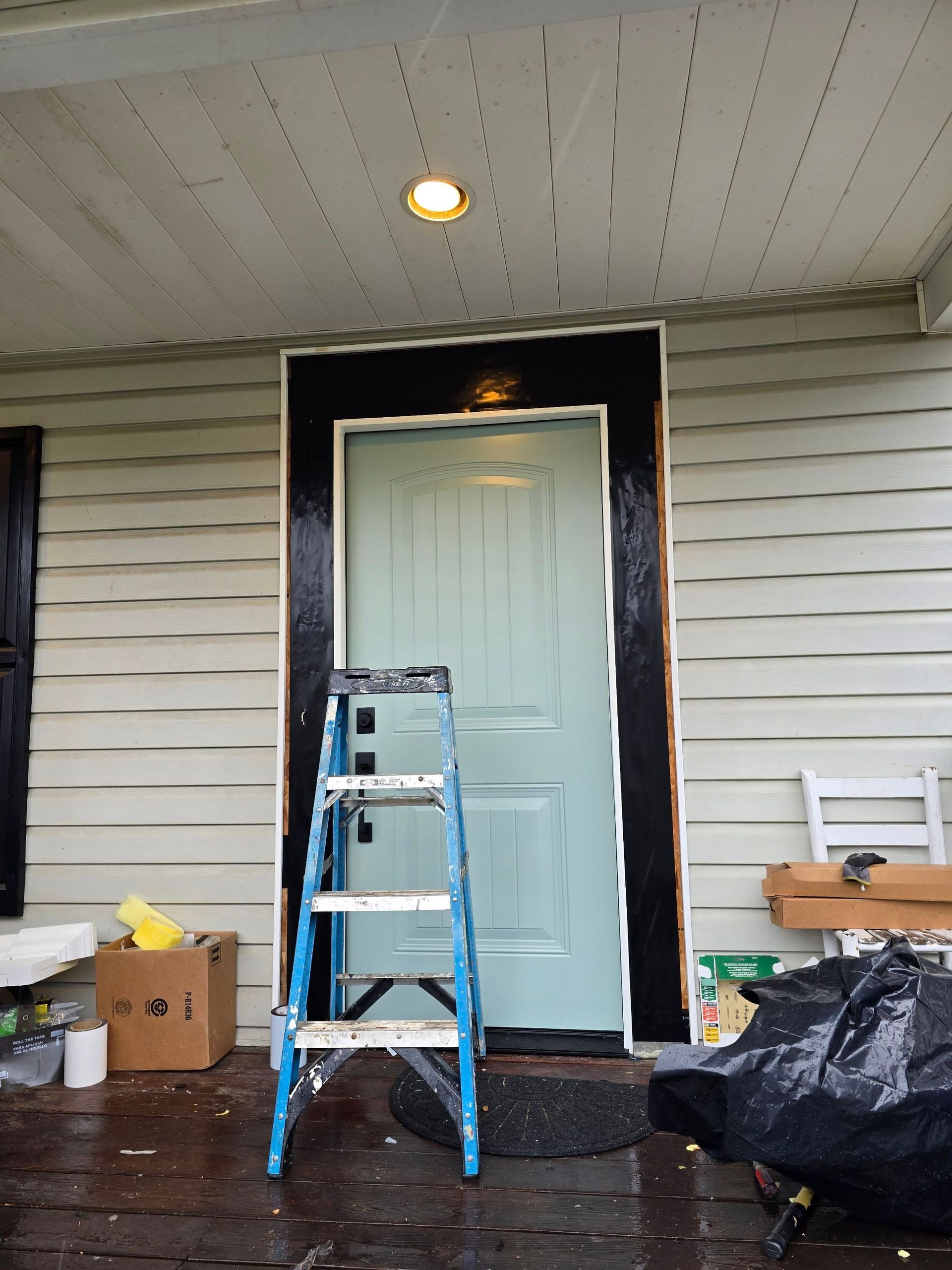 A blue ladder is sitting in front of a blue door