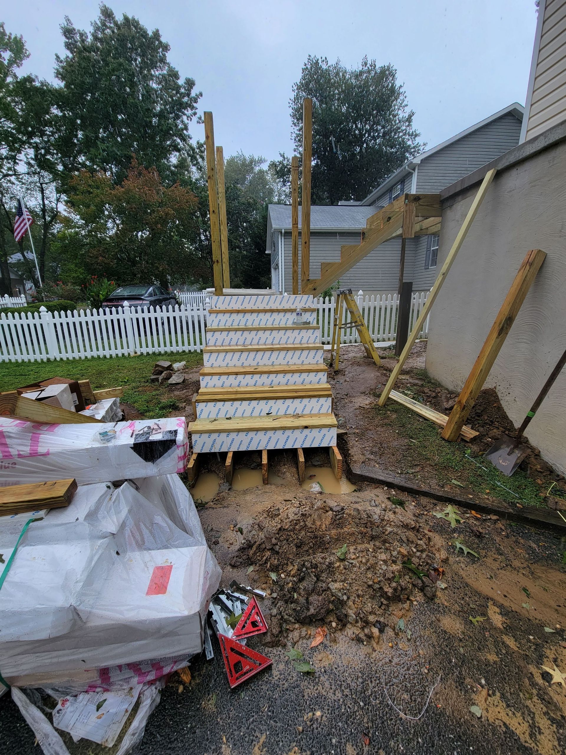 A staircase is being built in the backyard of a house.
