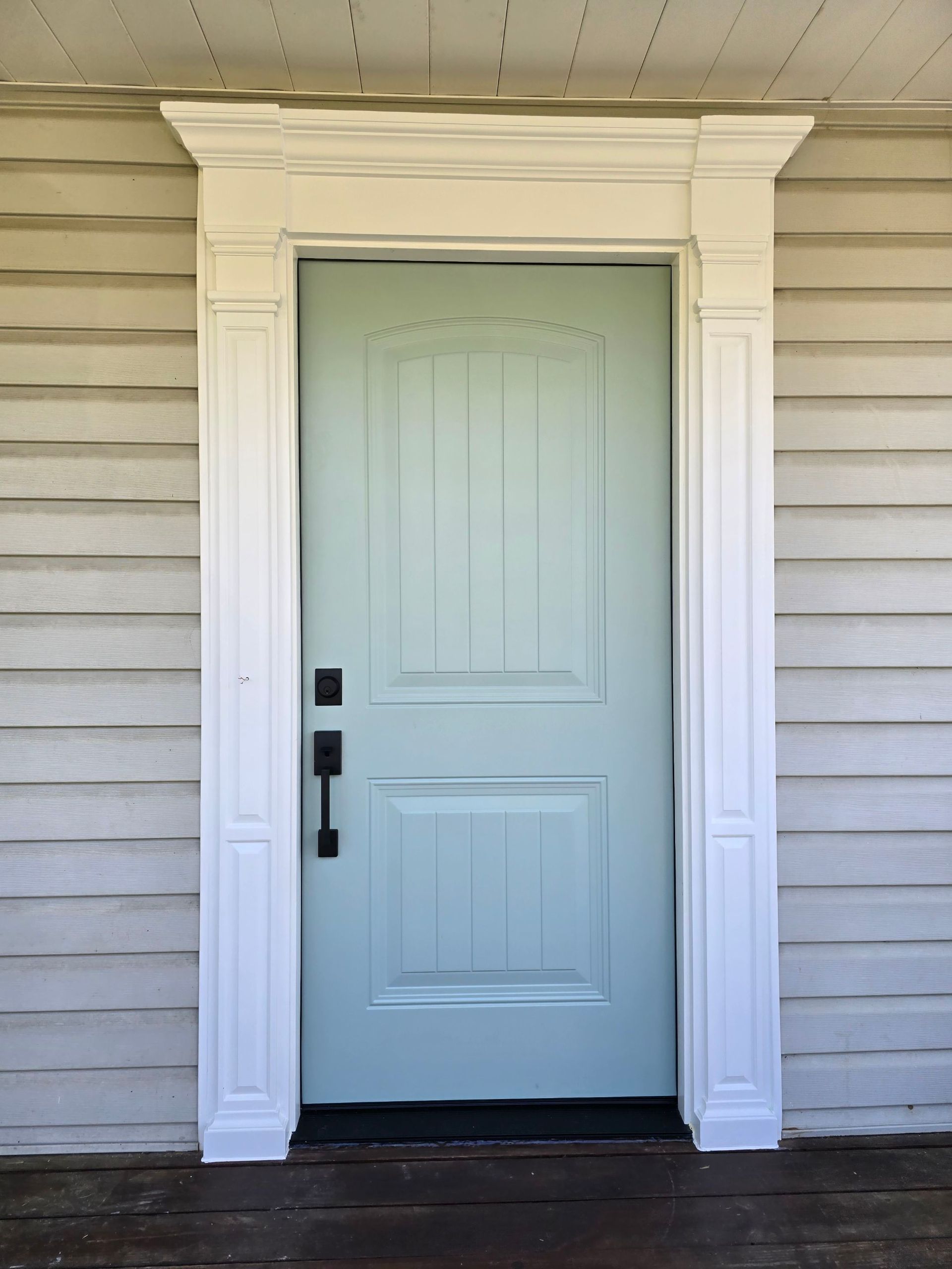 A light blue door on a white house