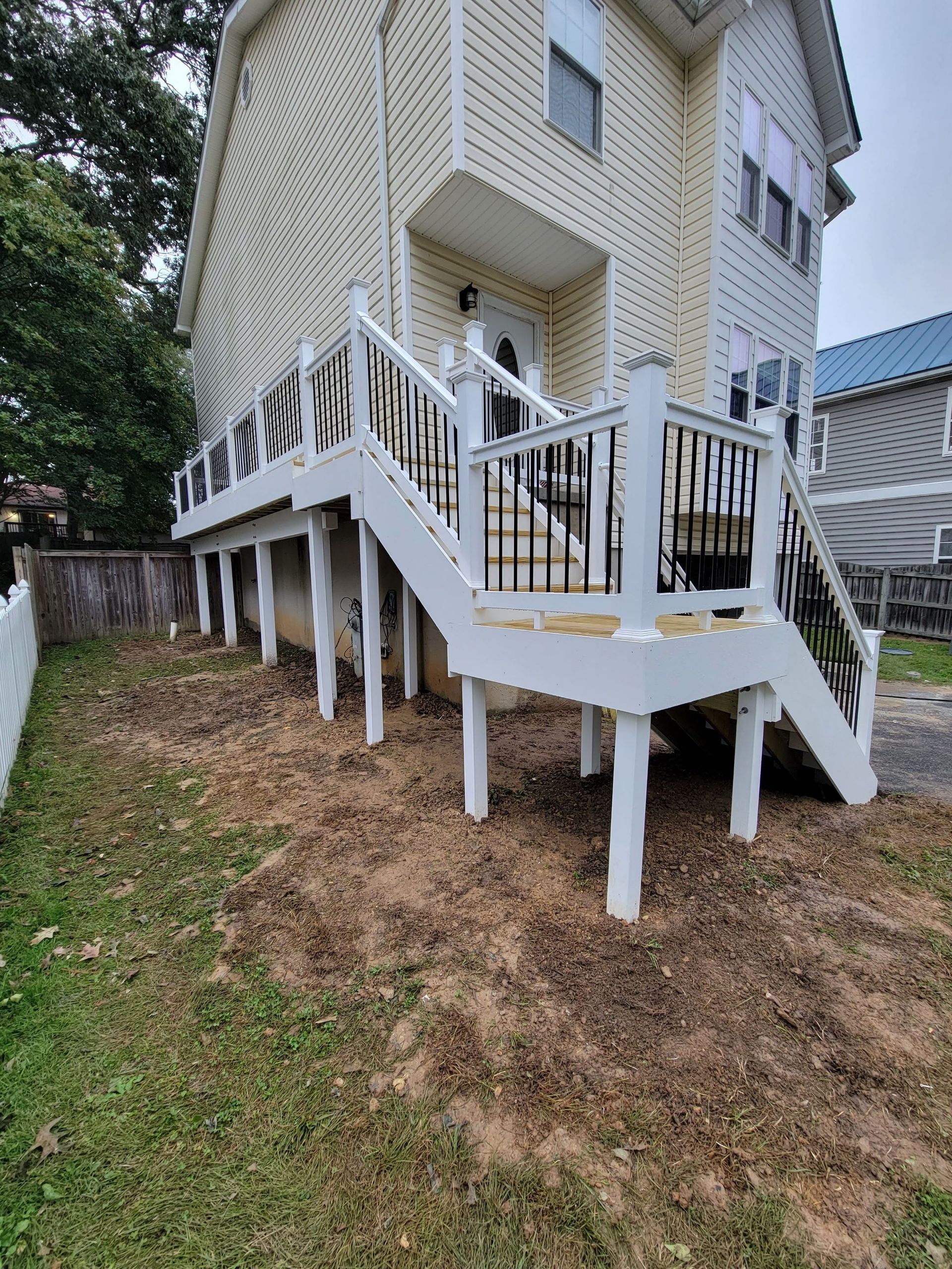 A house with a deck and stairs on the side of it.