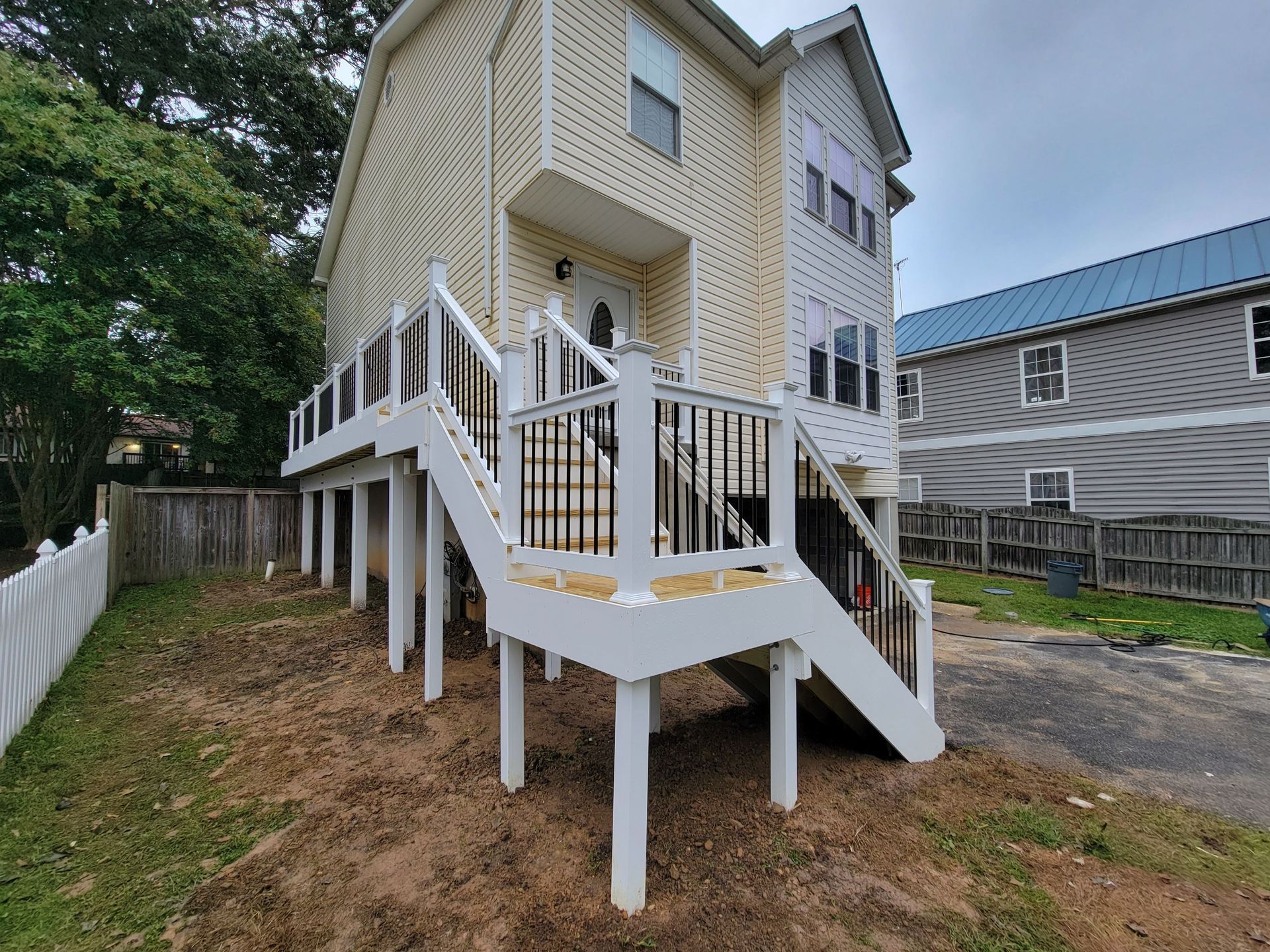 A house with a deck and stairs on the side of it.
